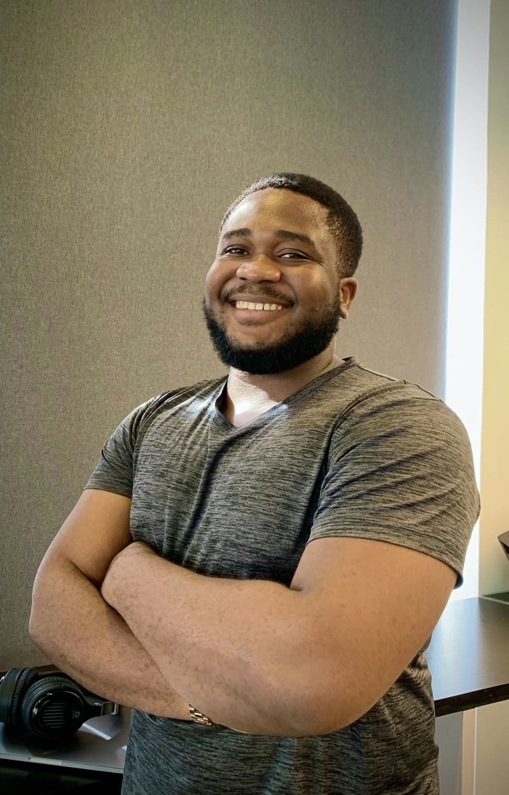 A confident man smiling with his arms crossed
