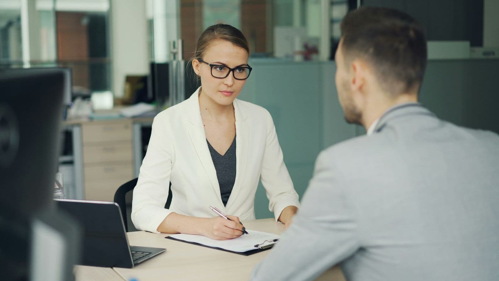 An interviewer talking with a candidate across a desk