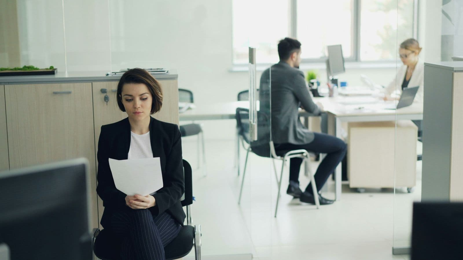 A candidate waiting with her papers before an interview